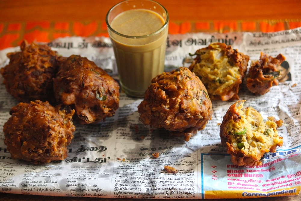 ulli vada served with masala chai on a newspaper