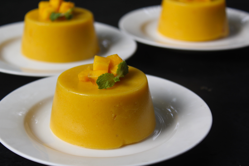 mango pudding served with chopped mangoes and mint leaves as garnish