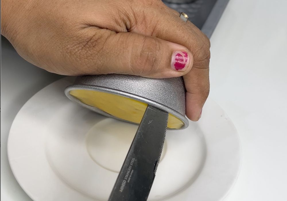 de moulding mango pudding using a butter knife