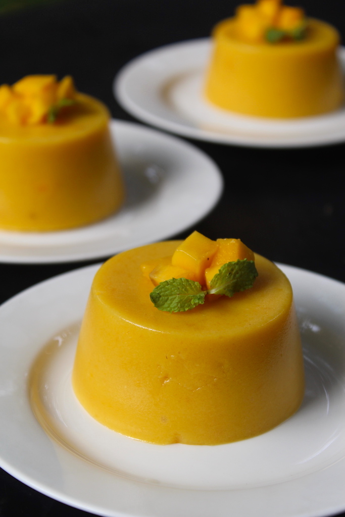 mango pudding served with chopped mangoes and mint leaves as garnish
