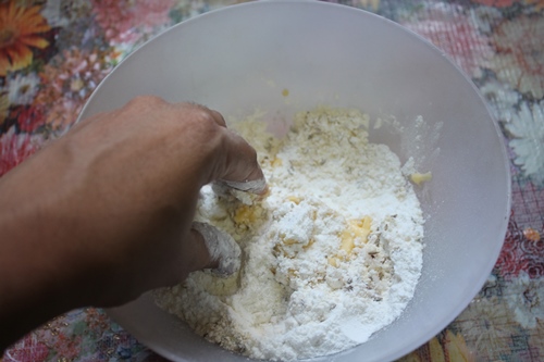 using hands to rub butter into the flour