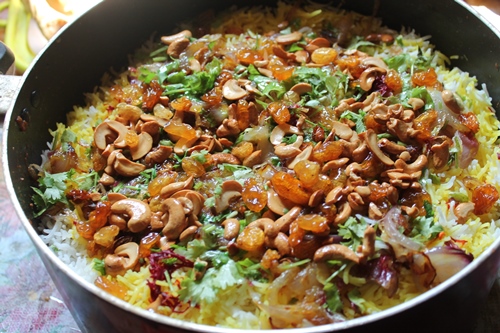 sprinkle the nuts and dried fruits over the biryani with the ghee