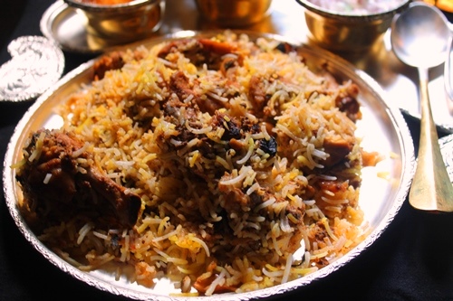 chicken dum biryani on a brass plate