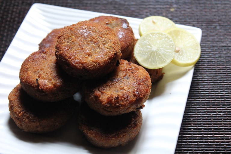 a plate of fried chicken cutlet served with lemon slices