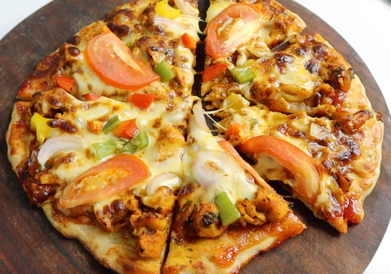 chicken pizza served on a wooden cutting board