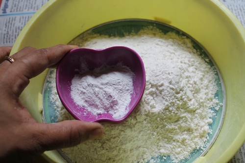 baking powder added to plain flour in a sieve