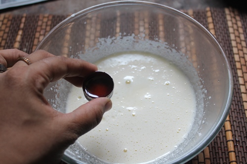 adding vanilla extract to whipped eggs and sugar