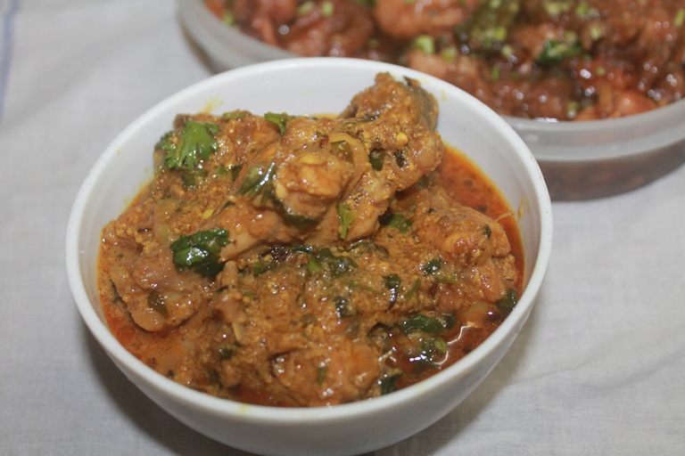 dahi chicken served in a bowl with coriander leaves as garnish