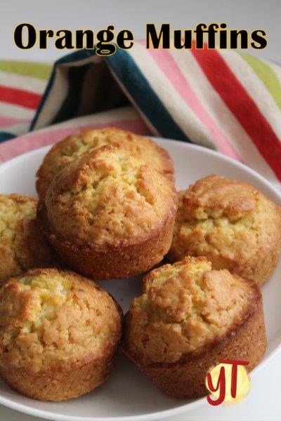 horizontal shot of orange muffins displayed on a white plate