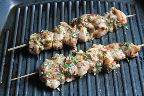 cook chicken kebab by placing on a hot grill pan 