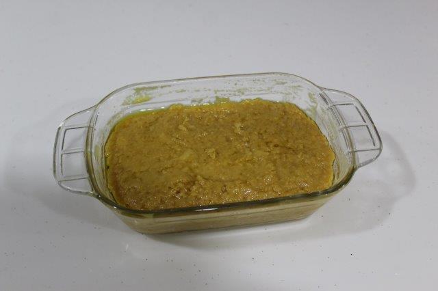 spoon milk cake mixture in mould and flatten the top