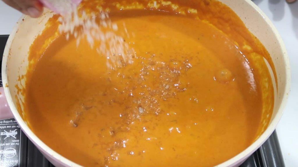 add sugar to paneer butter masala curry simmering shot