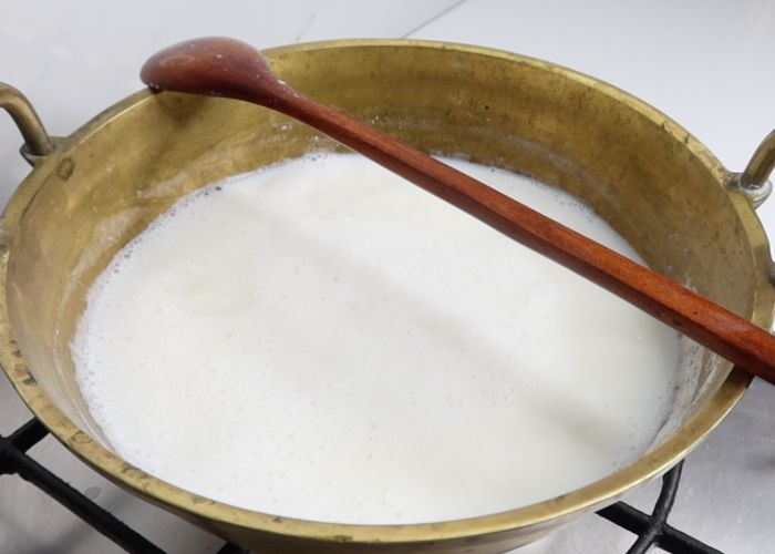 placing wooden spoon across the kadai will prevent the milk from overflowing