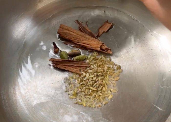 heat oil in a pressure cooker. add whole spices fennel seeds, cinnamon, cardamom and cloves