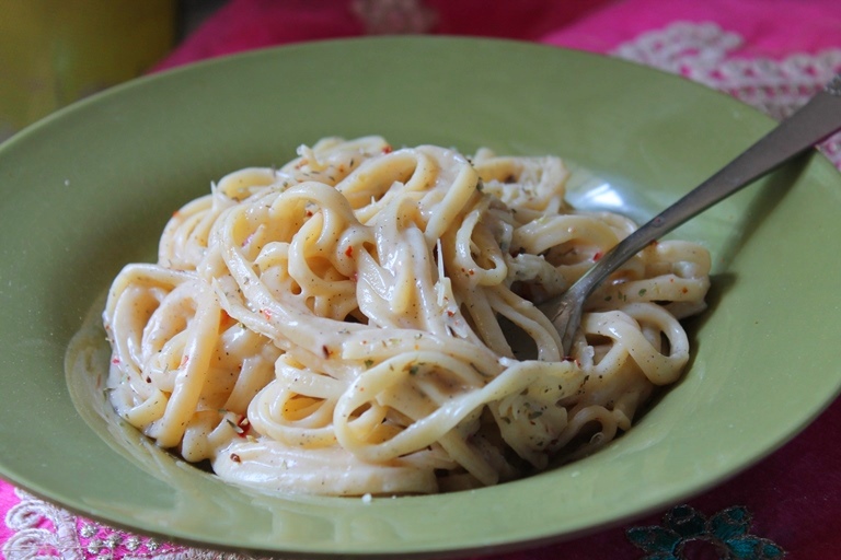 white sauce served with parmesan cheese and italian herbs on top