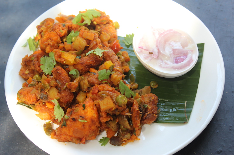 bread upma served on a banana leaf with onion raita