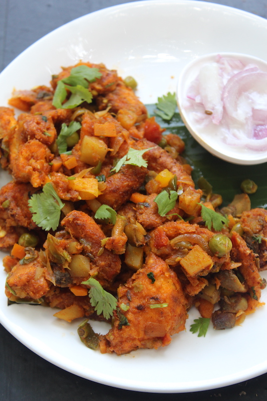 close shot of bread upma served on a banana leaf with onion raita