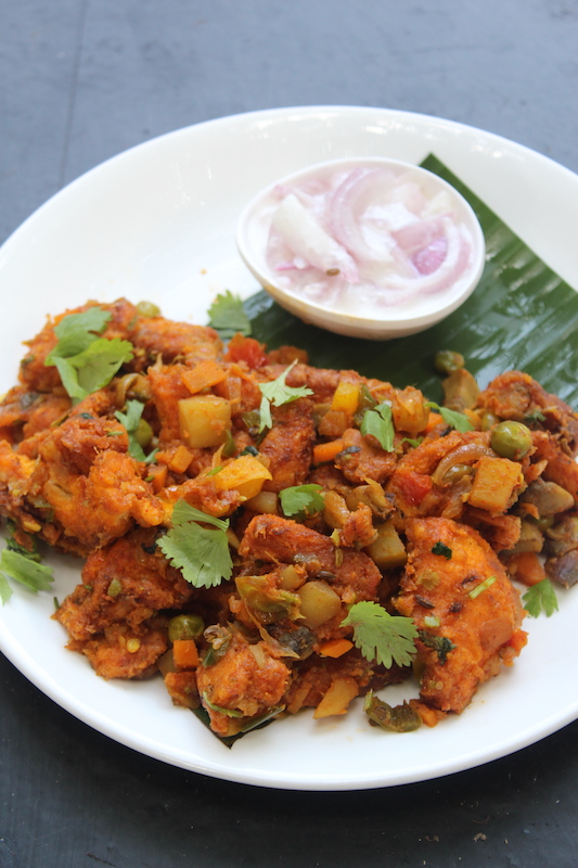 bread upma garnished with served on a banana leaf with onion raita