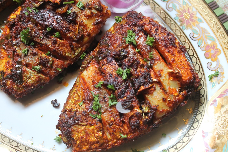 spicy tawa fish fry plated with onion rings