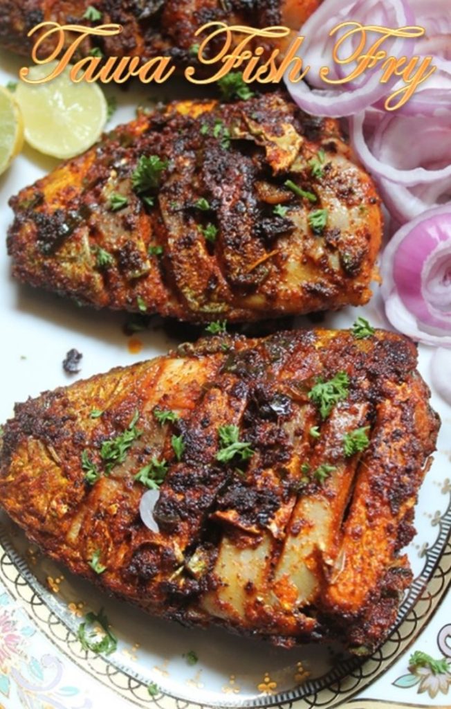 three pieces of fish fried till crispy and served with onion rings and lemon