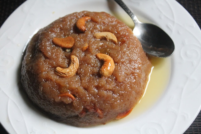 top angle of bread halwa served on a white plate garnished with cashews