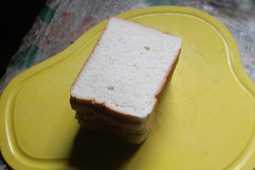 white bread slice on a yellow cutting board