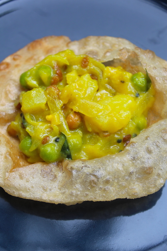 poori masala piled over a fried puri