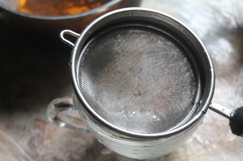take strainer and place over cup