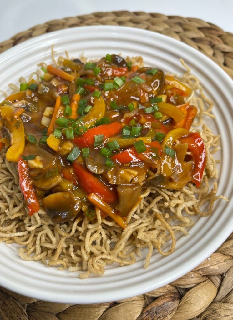 american chop suey - fried noodles topped with chop suey sauce and spring onions