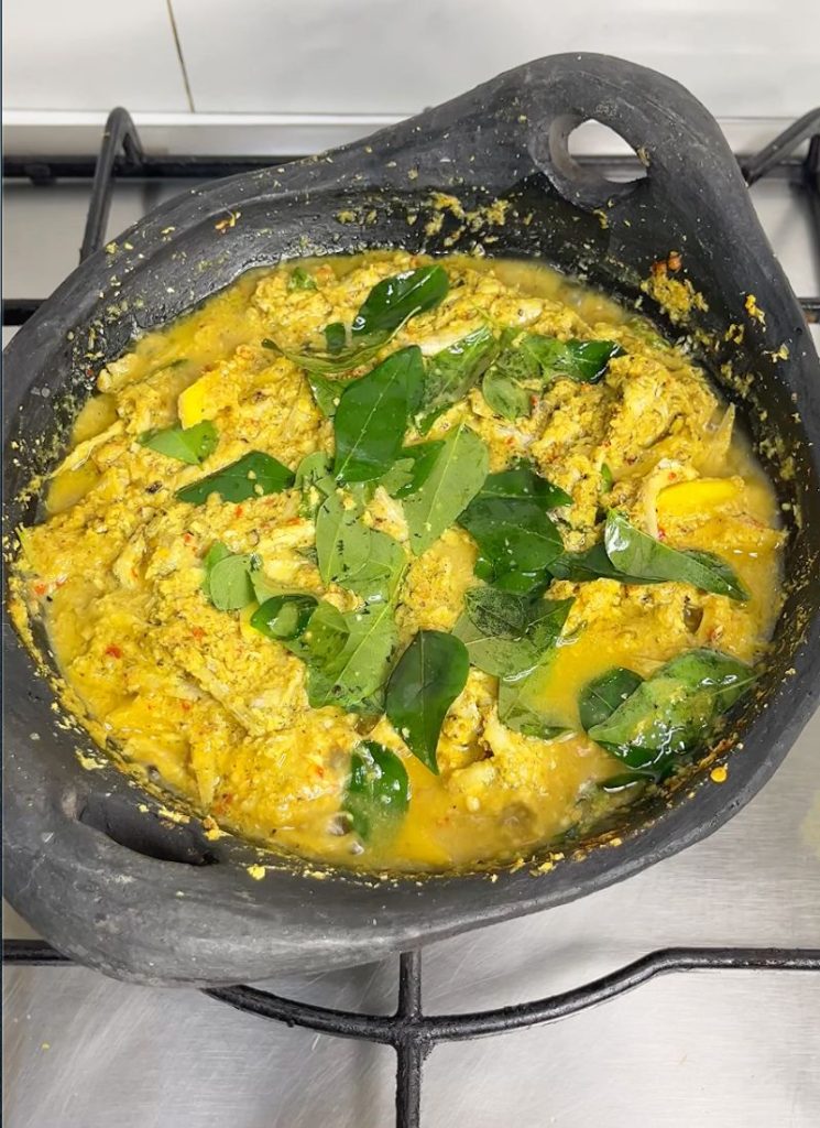 close shot of Meen Peera with curry leaves on top