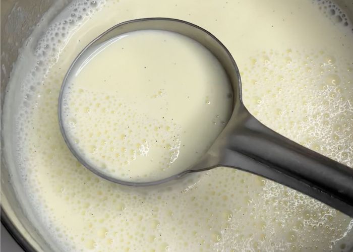 vanilla beans specked over the milk