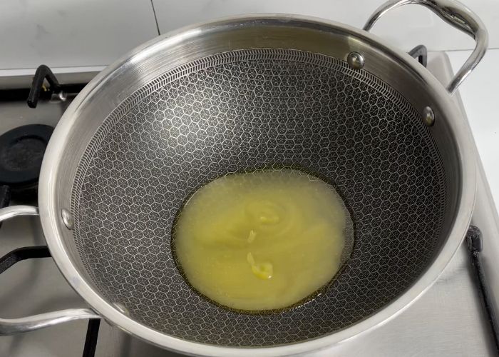 Heat ghee in a pan for making afghani chicken
