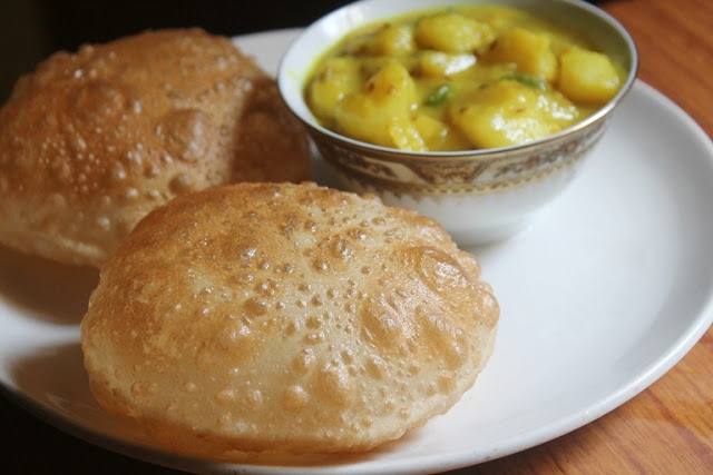 two puffed poori served with no onion and garlic aloo bhaji