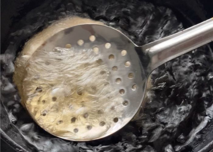 press on top of the puri disc using a slotted spoon