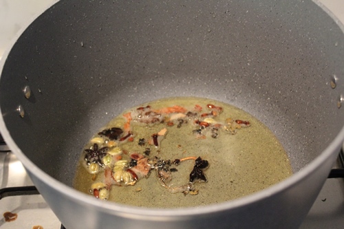 whole spices frying in oil in a pot