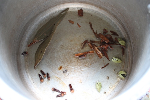 heat oil in a pressure cooker, add whole spices like cinnamon, bay leaf, cloves and cardamom