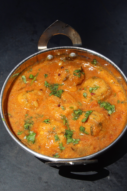 top angle paruppu urundai kuzhambu served in a steel karahi