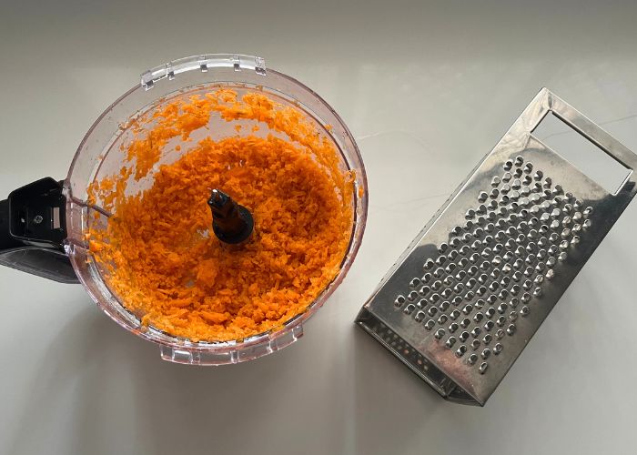 carrots grated in a food processor and traditional grater is shown in picture