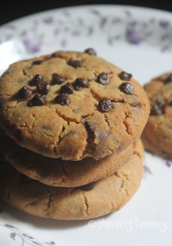 eggless chocolate chip cookies stacked on a plate