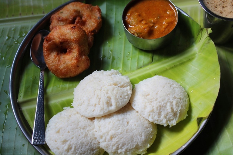 idli served on a banana leaf with medu vada, sambar and filter coffee