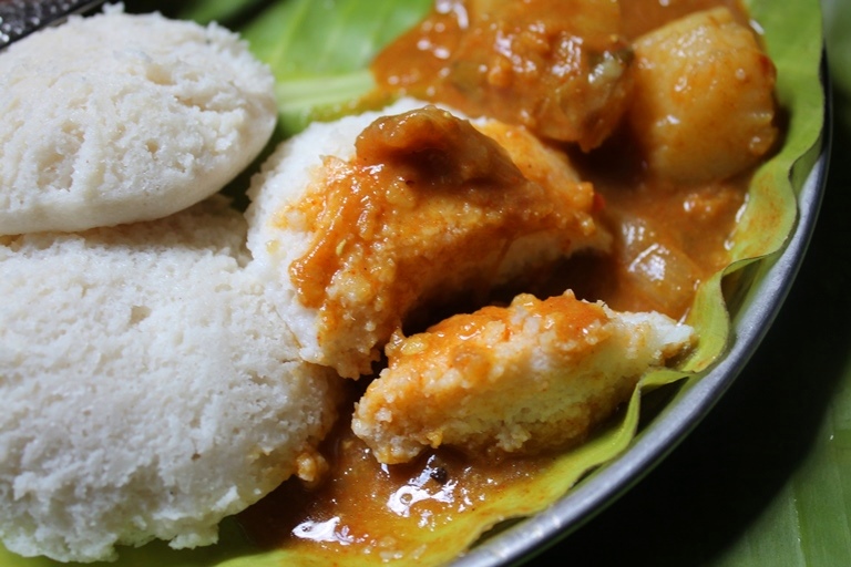 sambar poured over idli and soft texture of idli is shown