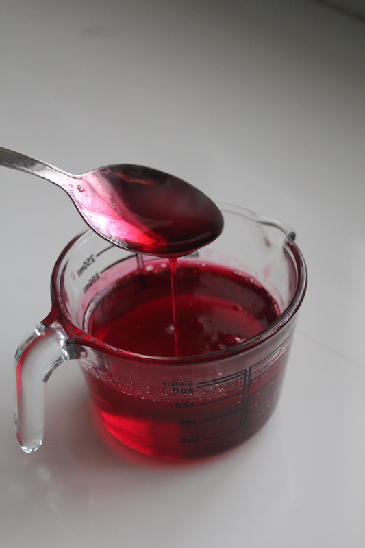 rose syrup consistency shown with a spoon