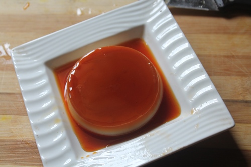 Eggless Caramel Custard in a white plate with caramel sauce