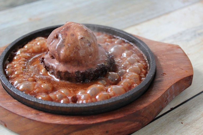 brownie served with ice cream and chocolate sauce in sizzler plate