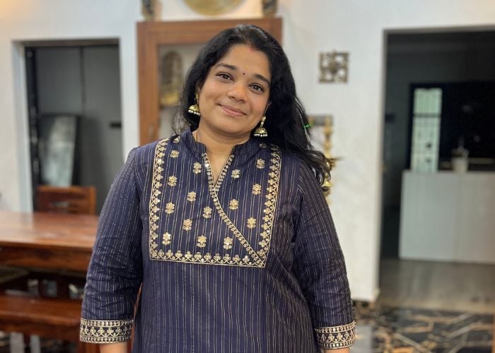 Aarthi Satheesh, founder of Yummy Tummy in a blue blouse inside her home.